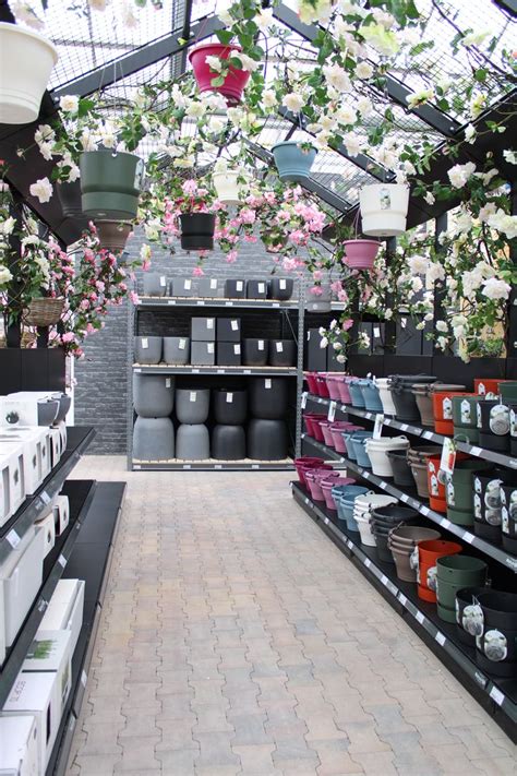 The Inside Of A Flower Shop Filled With Lots Of Pots And Flowers