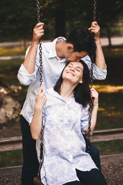 Sonriente Pareja De Enamorados En Un Columpio Al Aire Libre Foto Gratis