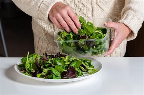 Premium Photo Middle Aged Blonde Woman Preparing Green Salad In The