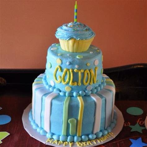 A Blue And White Birthday Cake With A Single Candle On Top That Says Cotton