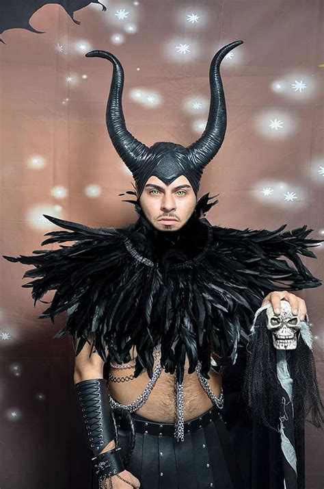 A Man Dressed In Black With Horns And Feathers