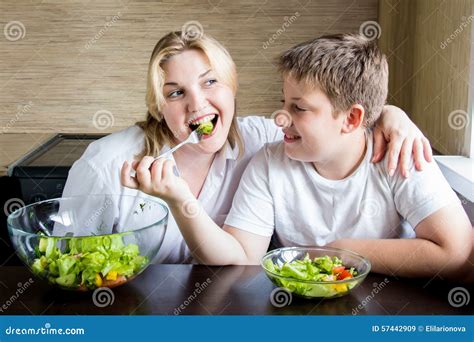 Madre E Hijo Que Comen La Ensalada Y Que Se Divierten Imagen De Archivo