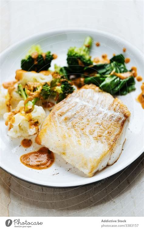 Fisch mit Gemüse und Sauce auf dem Teller ein lizenzfreies Stock Foto