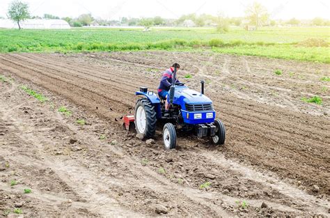 Un agricultor en un tractor cultiva un campo agrícola Fresado