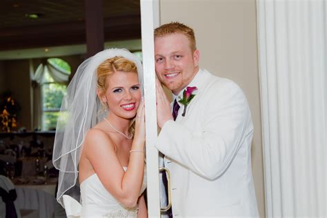 A Bride And Groom Posing For A Photo In Front Of The Door To Their