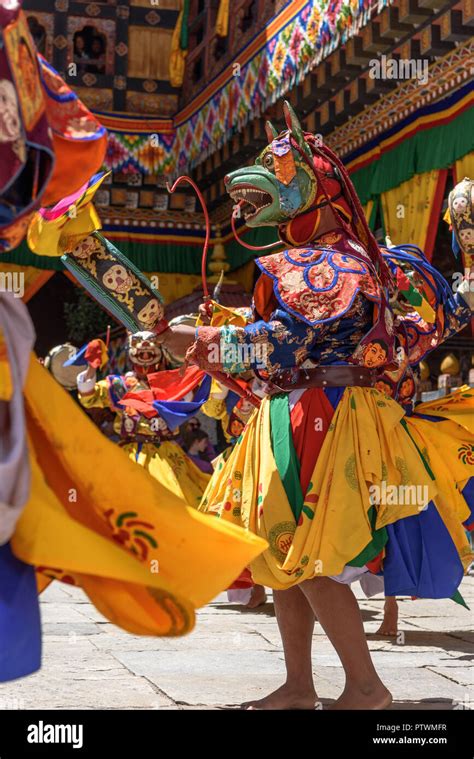 Buddhist Monk Dancing And Holding A Drum At Colourful Mask Dance At