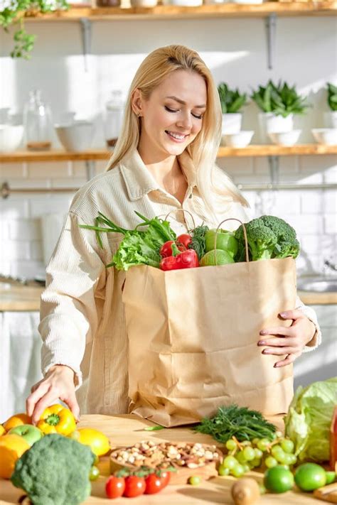 Smiling Caucasian Woman Holding Shopping Paper Bag With Fruits And