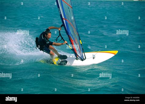 Single Male Windsurfer Screaming In Gybe Turn On Light Blue Water Of