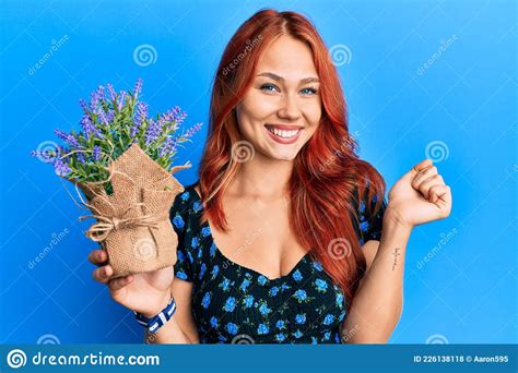 Young Beautiful Redhead Woman Holding Lavender Pot Screaming Proud Celebrating Victory And