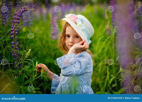 Une Belle Petite Fille En Robe Bleue Et Chapeau De Paille Dans Un Champ