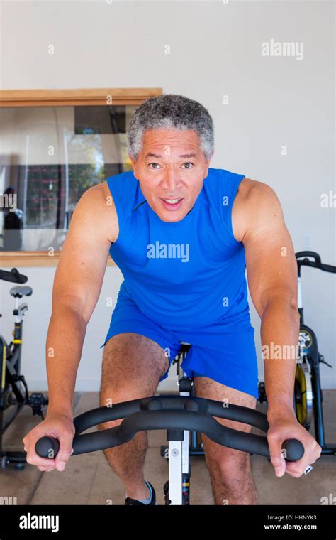 Mixed Race Man Riding Stationary Bicycle In Gymnasium Stock Photo Alamy