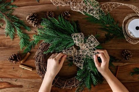 Premium Photo Overhead Shot Of Hands Making Handmade Christmas Wreath