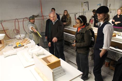 A Group Of People Standing Around In A Room