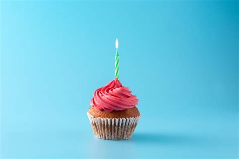 Premium Photo Pink Birthday Cupcake With Green Candle On Blue Background