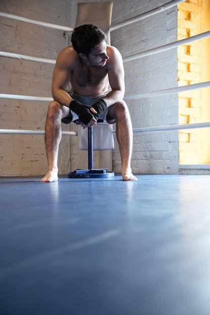 Joven Boxeador Sentado En La Esquina Del Ring De Boxeo Foto Premium