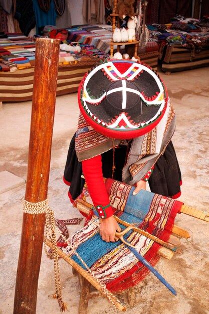 Premium Photo Woman In Traditional Peruvian Costume Weaving Alpaca