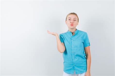 Free Photo Blonde Woman Pouting Lips Spreading Palm Aside In Blue Blouse Isolated