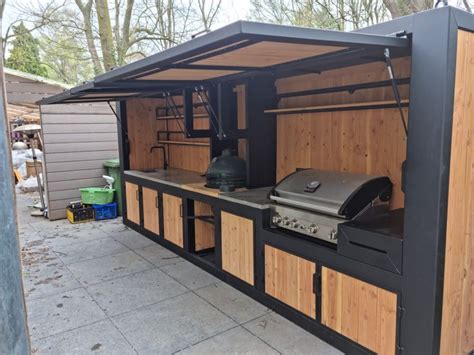 An Outdoor Bbq With Wood Cabinets And Grill