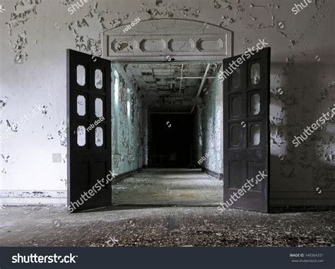 Open Doors Leading Into A Hallway Inside An Abandoned Mental Hospital