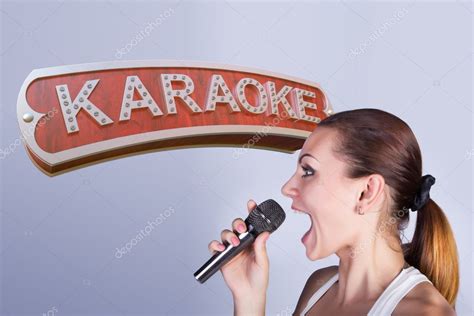 Girl with a microphone on the background of sign of karaoke. — Stock Photo © SectoR_2010 #101242950