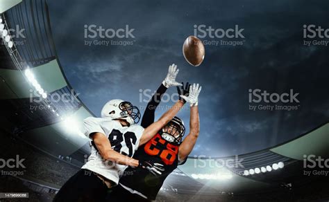 Dynamic Shot Of Male Sportsmen Professional American Football Players During Game Catching Ball