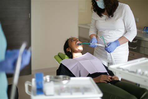 Dental assistant curing teeth of black womanFree Stock Photo