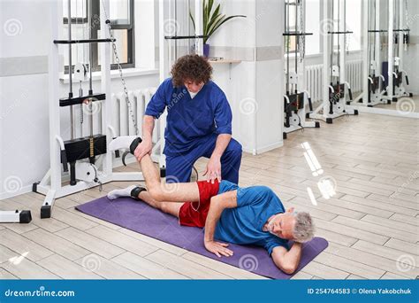 Ejercicios De Un Anciano Con Su Entrenador En El Centro De