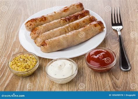 Fried Sausage In Plate Ketchup Mayonnaise Mustard And Fork Stock