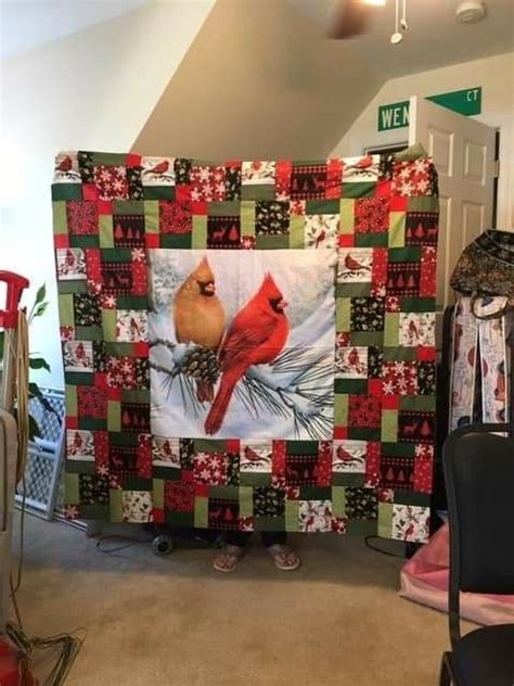 A Red Cardinal Bird On A Quilt Hanging In The Corner Of A Room With Chairs