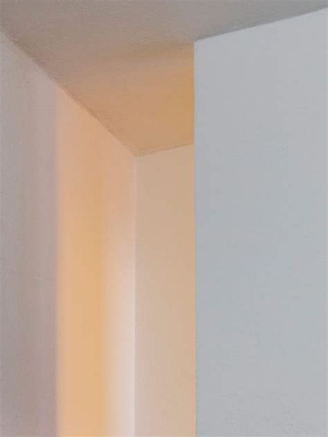 The Corner Of A White Room With Light Coming In