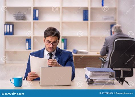 Jefe Masculino Viejo Y Empleado Joven En La Oficina Foto De Archivo