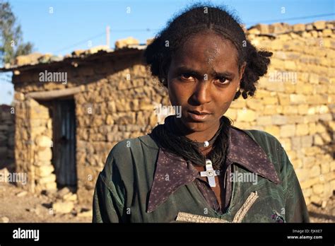 Young woman belonging to the Agaw people. She is standing in front of ...