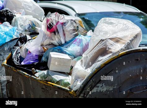 A Crowded Trash Can Filled With Trash Bags And Waste A Close Up Of A