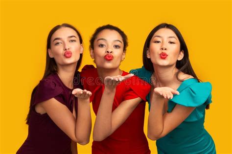 Three Beautiful Girls Sending Air Kiss Standing In Studio Panorama