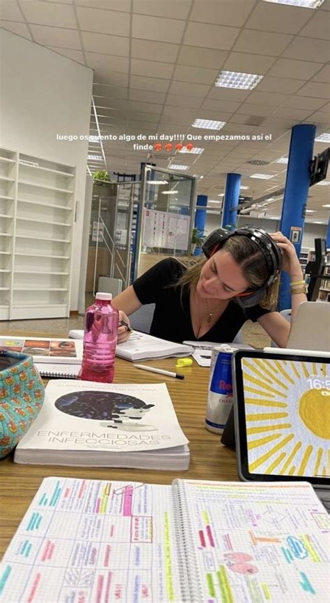 A Woman Sitting At A Desk With Papers And Laptops On It Listening To