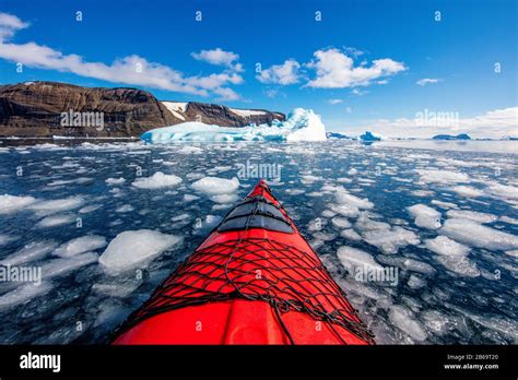 Kayaking Through The Frozen Oceans And Icebergs Of Antarctica In A Red