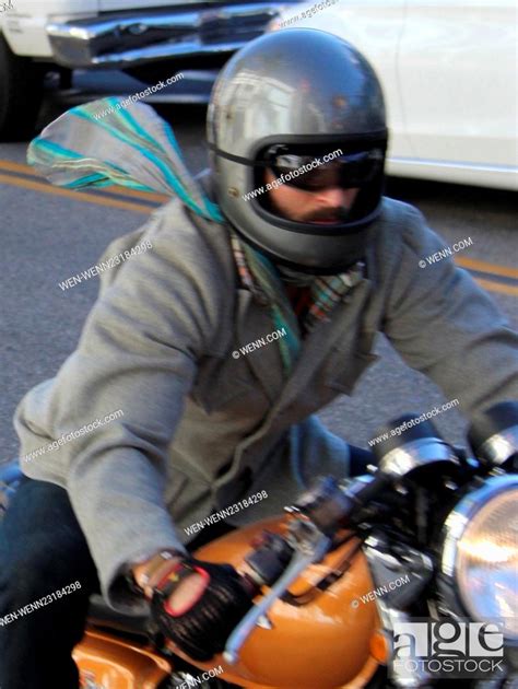 Keanu Reeves riding his motorbike with a silk scarf flying in the wind ...