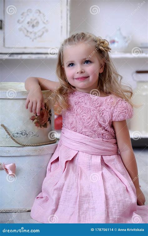 Jolie Petite Fille Blonde En Robe Rose Avec Des Boucles Photo Stock