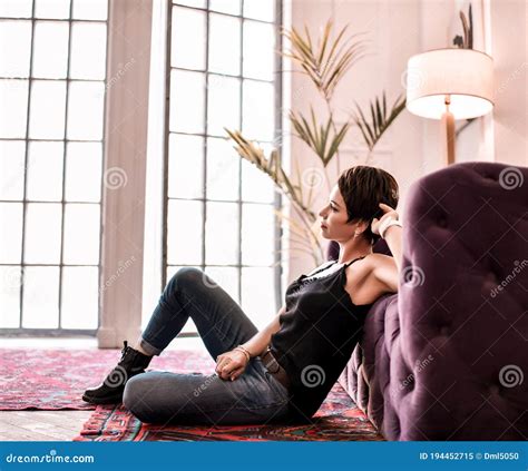 Relaxed Short Haired Brunette Woman In Stylish Black Shirt Blue Jeans