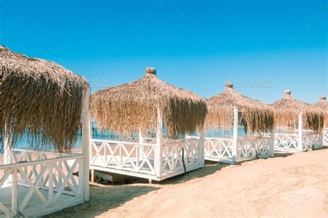 Massage Huts With Thatched Roof On Sand Beach Along Seaside Luxury