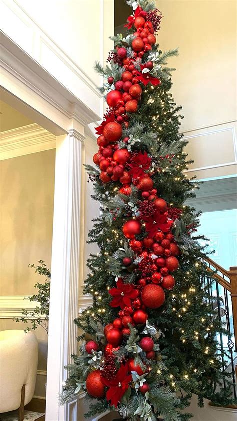 A Christmas Tree Decorated With Red Balls And Greenery