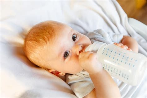 Mignonne Petite Fille Nouveau Née Buvant Du Lait De La Bouteille Et