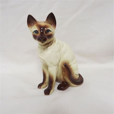 A Cat Figurine Sitting On A White Surface