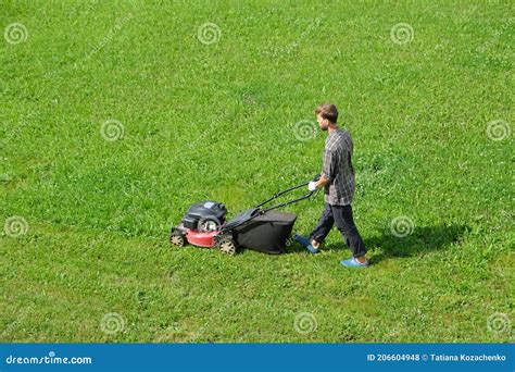 Aerial Drone View Of Gardener Mowing Green Grass Lawn With Motorized