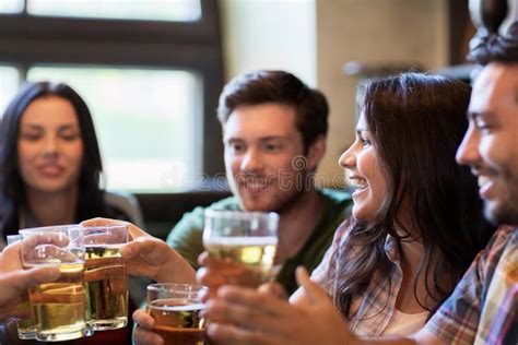 Amigos Felizes Que Bebem A Cerveja Na Barra Ou No Bar Imagem De Stock