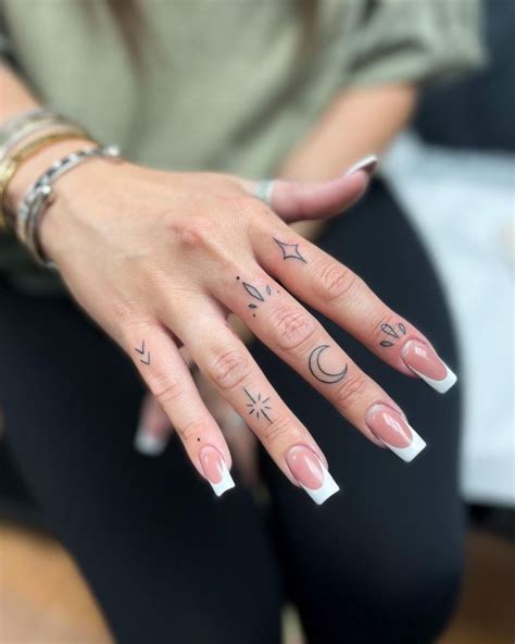 A Woman S Hand With Tattoos On It And Two Fingers In The Shape Of Arrows