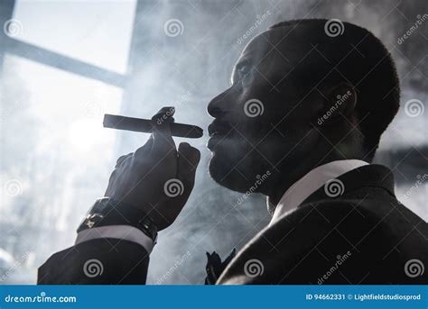 Confident African American Man Smoking Cigar Indoors Stock Image