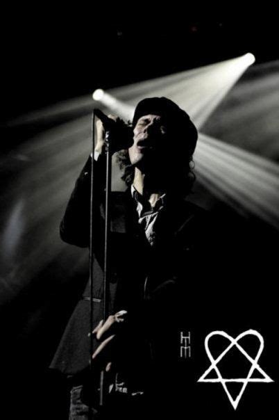 A Man Standing In Front Of A Microphone On Top Of A Stage With Lights