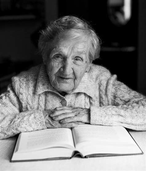 Um Retrato De Uma Senhora Idosa Lendo Um Livro Em Sua Própria Casa