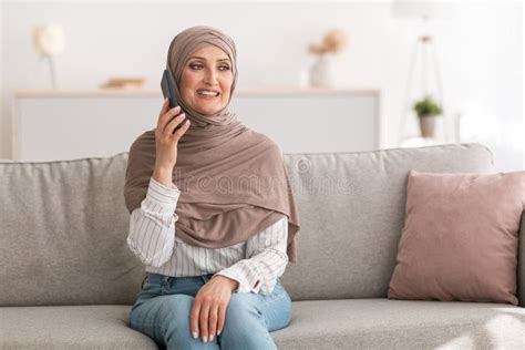 Feliz S Nior No Hijab Falando No Celular Sentado No Interior Foto De